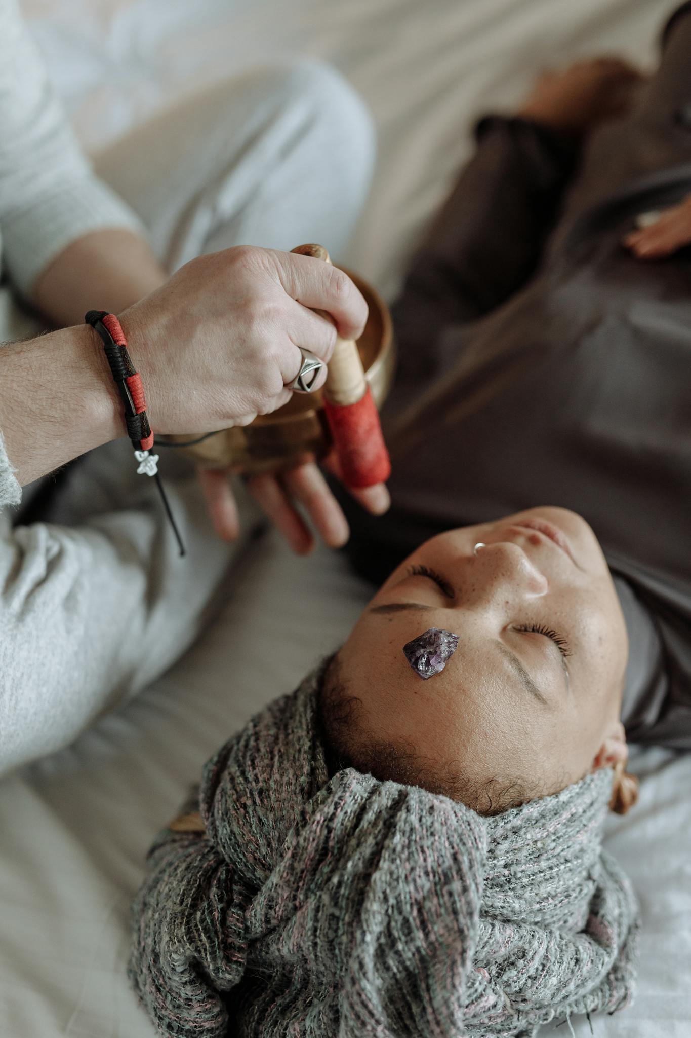 A woman experiencing spiritual healing through sound therapy and meditation indoors.